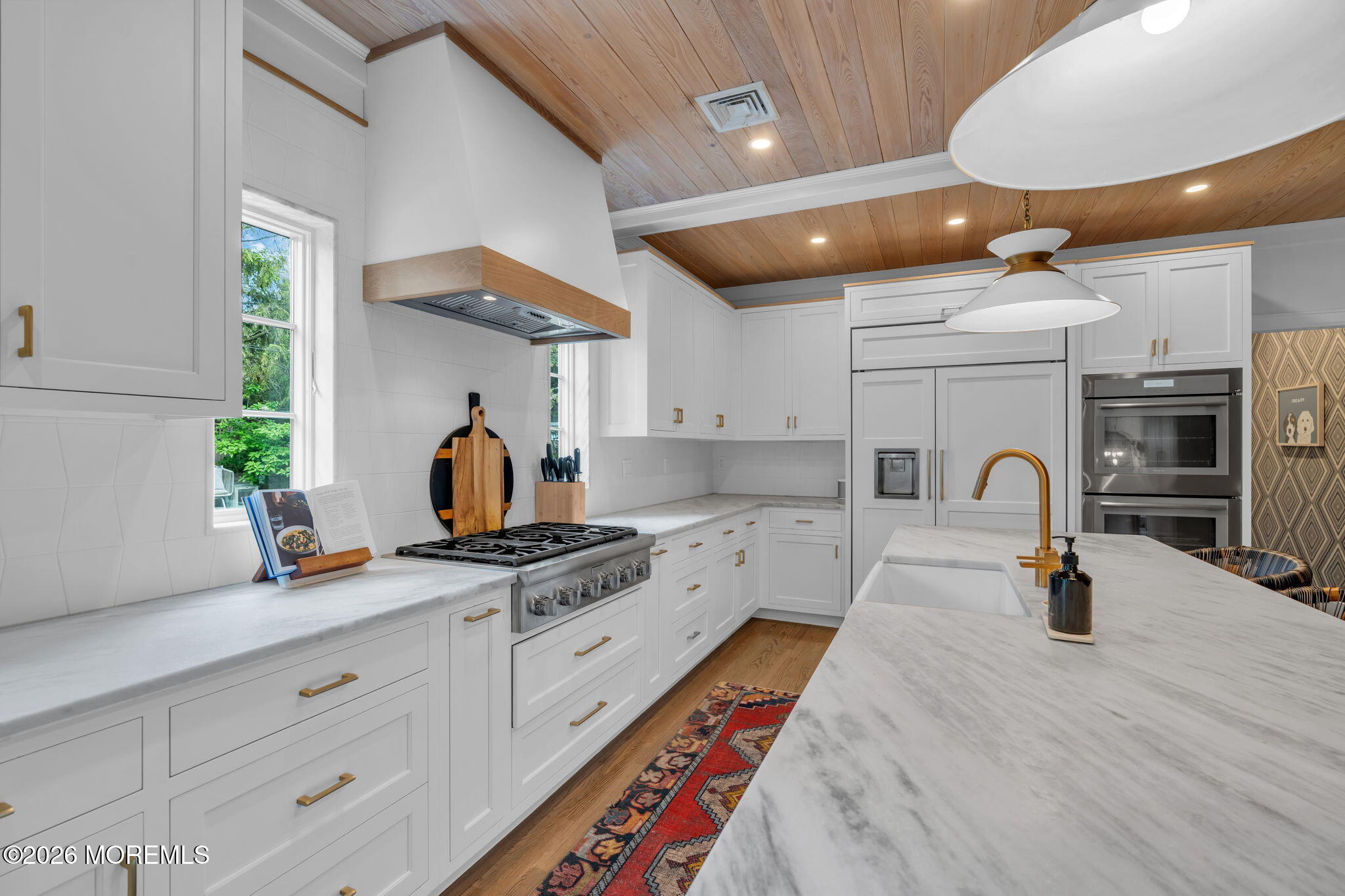 22 1st Street Rumson, NJ 07760 - Photo 12 of 44 a kitchen with stainless steel appliances granite countertop a stove a sink dishwasher and white cabinets with wooden floor