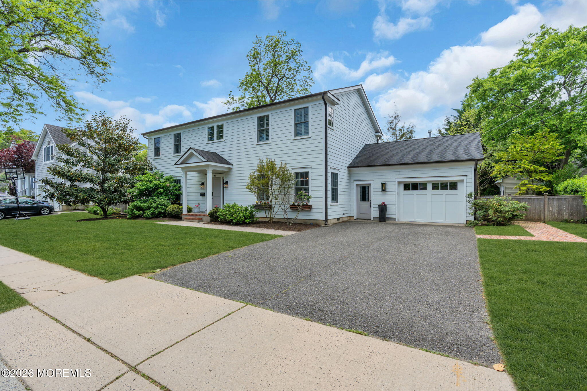 22 1st Street Rumson, NJ 07760 - Photo 2 of 44 a view of a white house with a small yard plants and a large tree