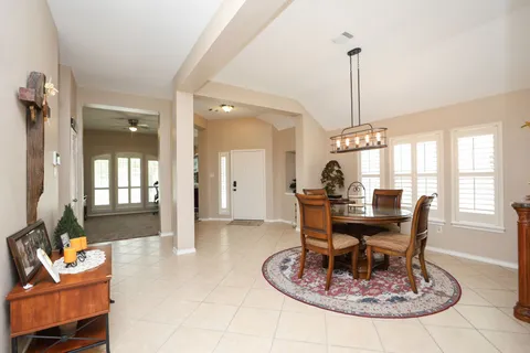 a kitchen with stainless steel appliances granite countertop a stove a refrigerator a sink a dining table and chairs with wooden floor