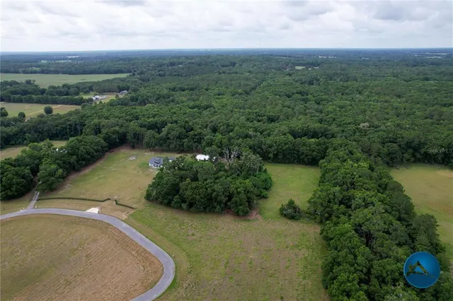 an aerial view of a house with a yard and lake view
