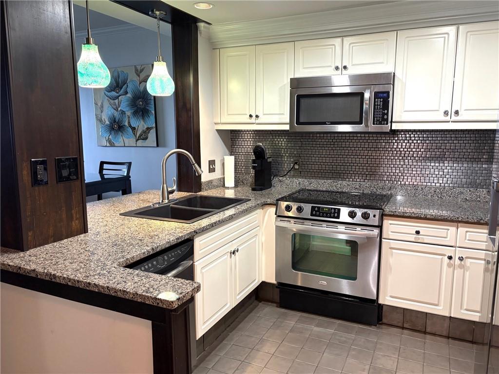 75 14th Street Northeast, Unit 3340 Atlanta, GA 30309 - Photo 3 of 24 a kitchen with granite countertop a sink stainless steel appliances and a counter space
