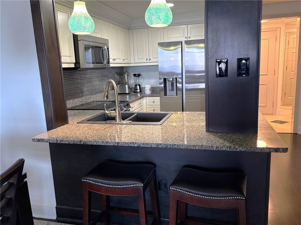 75 14th Street Northeast, Unit 3340 Atlanta, GA 30309 - Photo 5 of 24 a kitchen with granite countertop a sink cabinets and window