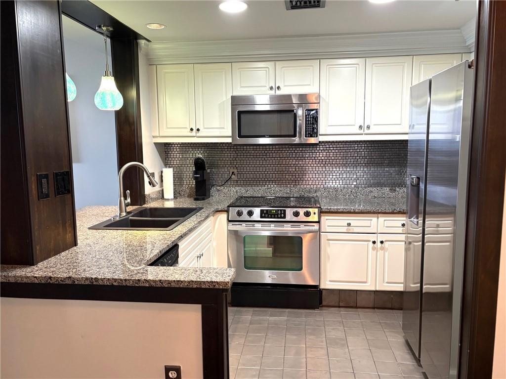 75 14th Street Northeast, Unit 3340 Atlanta, GA 30309 - Photo 6 of 24 a kitchen with stainless steel appliances granite countertop a stove a sink and a microwave