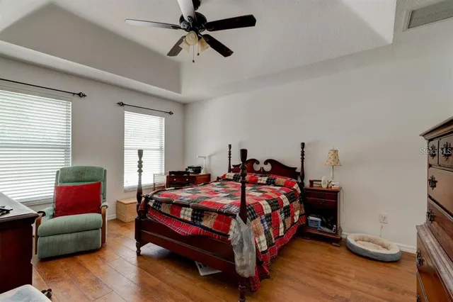 a bedroom with bed and wooden floor