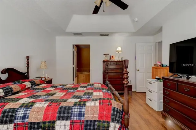a bedroom with a bed and a flat tv screen on a dresser