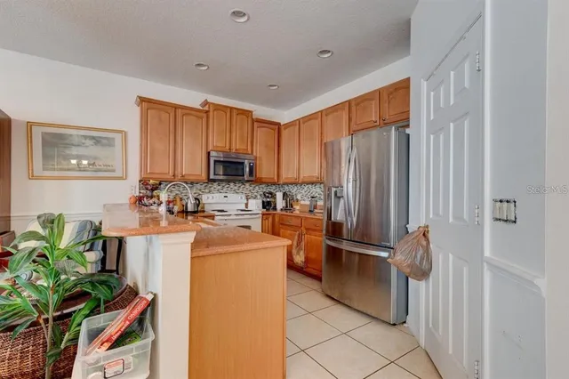 a kitchen with stainless steel appliances granite countertop a refrigerator and a stove top oven