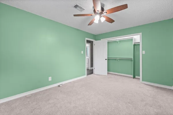 an empty room with closet and fan