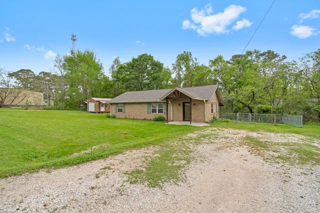 a view of a house with backyard and a tree