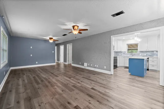 a view of a kitchen with wooden floor and a ceiling fan