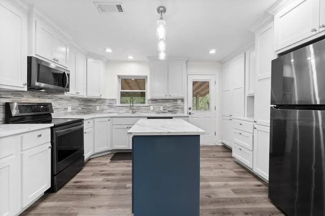a kitchen with white cabinets and stainless steel appliances