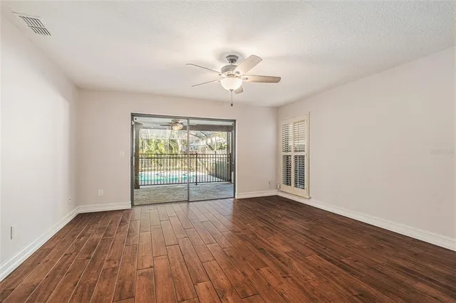a view of empty room with wooden floor and window