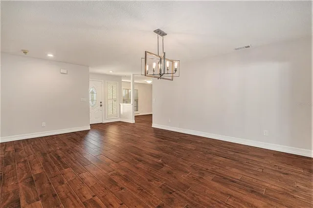 an empty room with wooden floor and a window