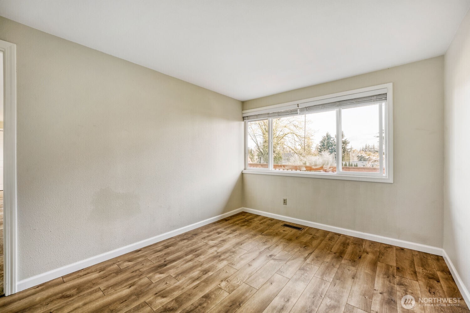 3618 South 243rd Street Kent, WA 98032 - Photo 11 of 37 an empty room with wooden floor and windows