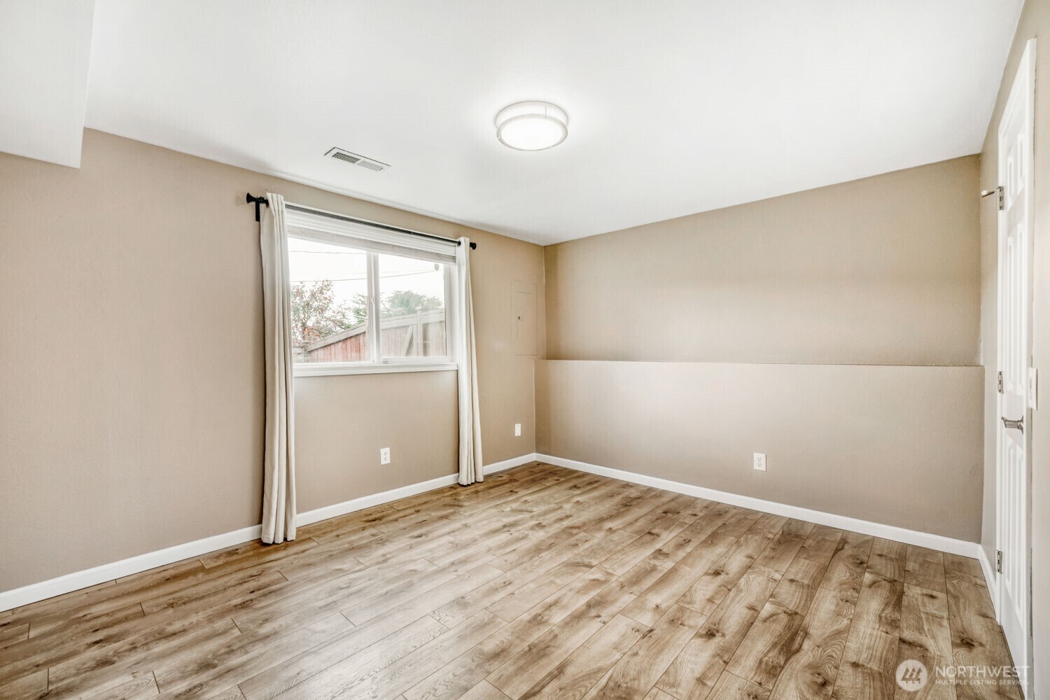 3618 South 243rd Street Kent, WA 98032 - Photo 20 of 37 an empty room with wooden floor and windows