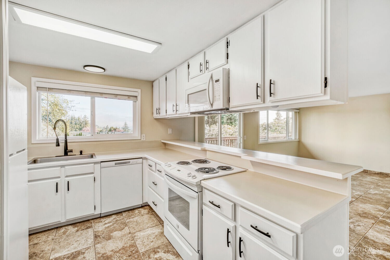 3618 South 243rd Street Kent, WA 98032 - Photo 8 of 37 a kitchen with stainless steel appliances granite countertop a sink dishwasher a stove and white cabinets with wooden floor