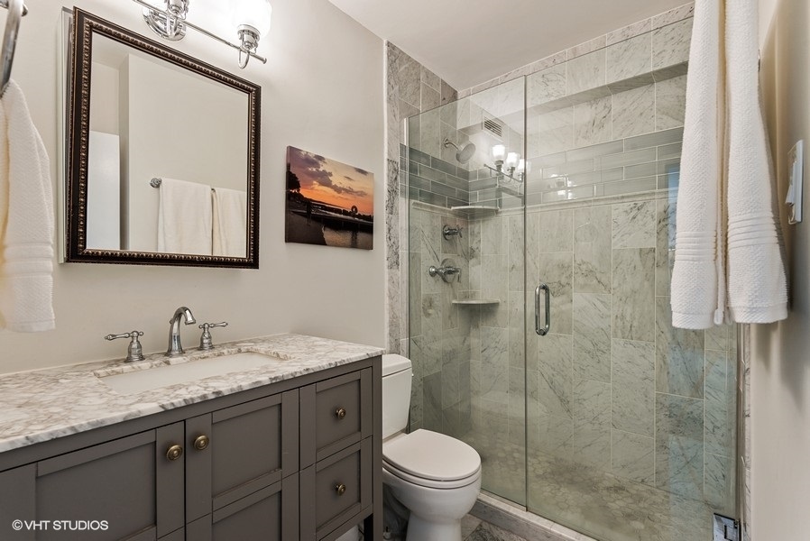 1616 Sheridan Road, Unit 5H Wilmette, IL 60091 - Photo 15 of 26 a bathroom with a granite countertop sink toilet and shower