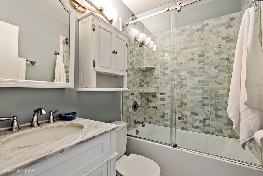 1616 Sheridan Road, Unit 5H Wilmette, IL 60091 - Photo 18 of 26 a bathroom with a granite countertop sink toilet and shower