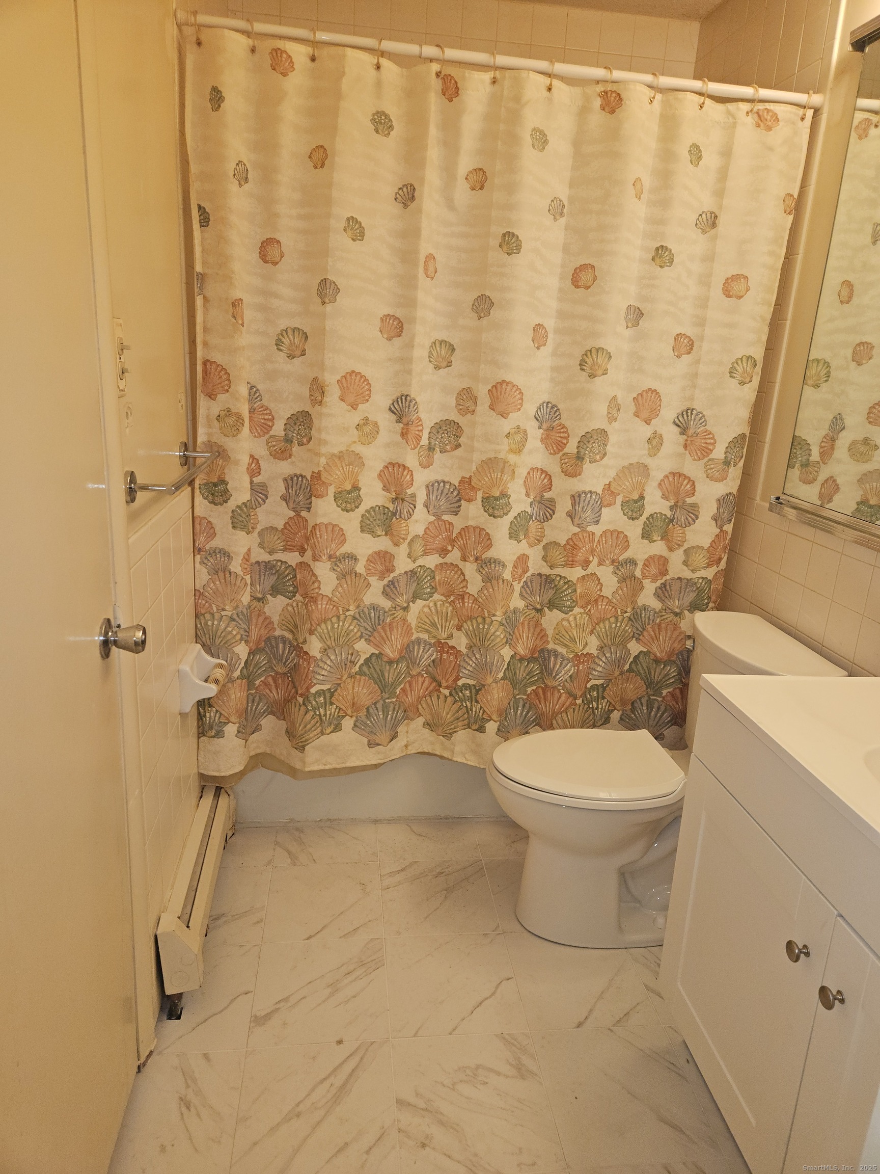 38 Sutton Place, Unit 38 Bloomfield, CT 06002 - Photo 15 of 17 a white toilet sitting next to a shower curtain