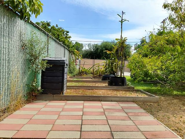 a front view of a house with a yard and potted plants