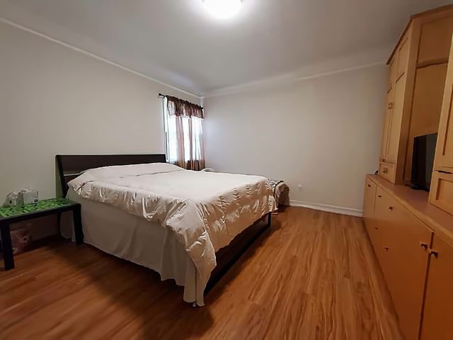 a bedroom with a bed tv on table and a window
