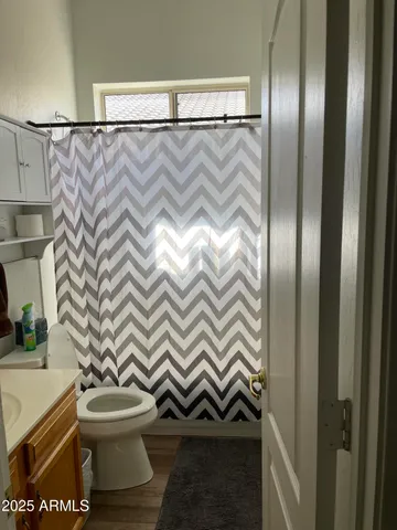 a bathroom with a toilet and a shower curtain