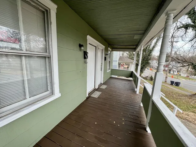 a view of a balcony with wooden floor and iron stairs