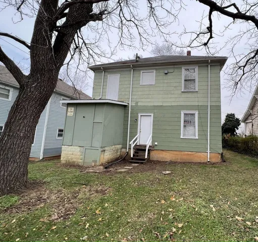 a backyard of a house with table and chairs