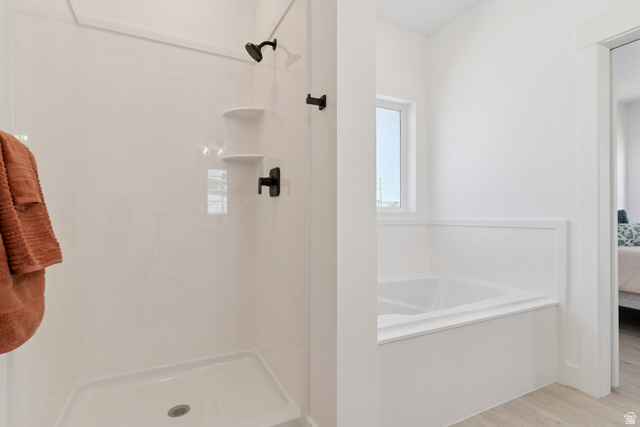 5777 West 4100 South Hooper, UT 84315 - Photo 17 of 41 Bathroom featuring ensuite bath, a stall shower, a garden tub, and light wood-style floors