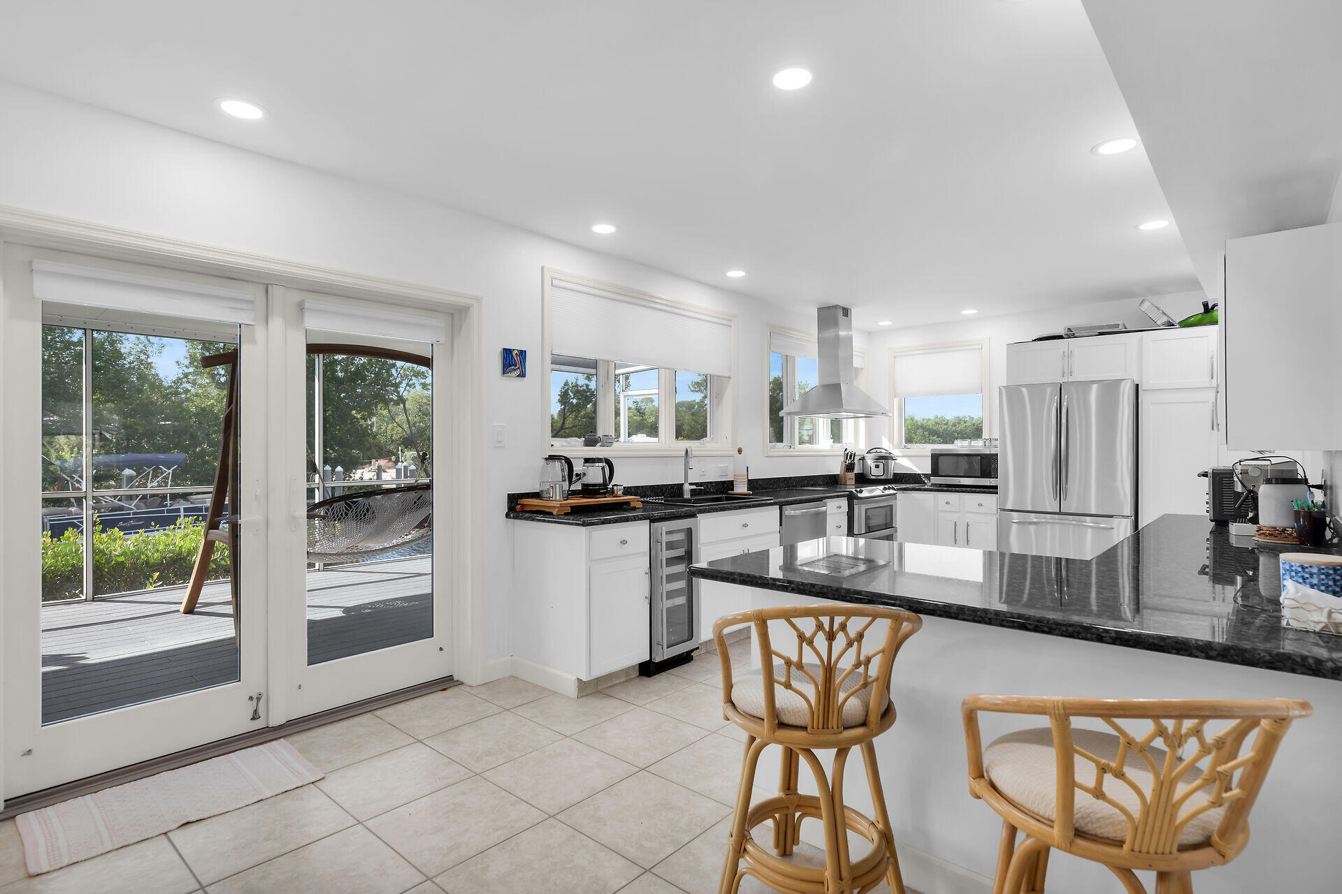 7501 Gulfstream Boulevard Marathon, FL 33050 - Photo 12 of 48 a kitchen with stainless steel appliances kitchen island granite countertop a refrigerator a sink a stove and white cabinets with wooden floor