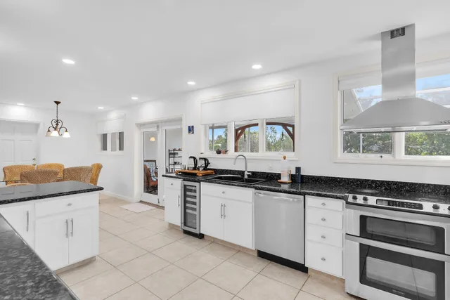 a large kitchen with granite countertop a sink and cabinets