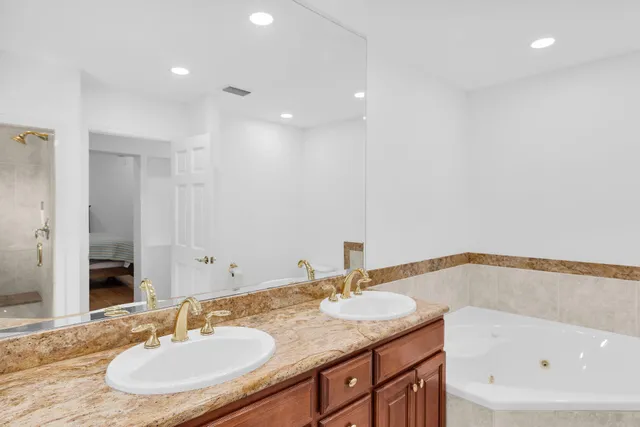 a bathroom with a granite countertop sink and a bathtub