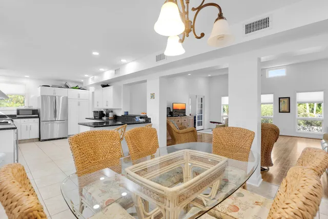 a living room with furniture kitchen view and a chandelier