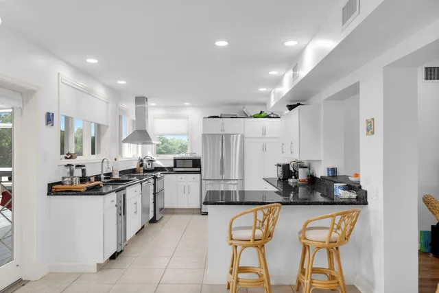 a kitchen with stainless steel appliances kitchen island granite countertop a sink and cabinets