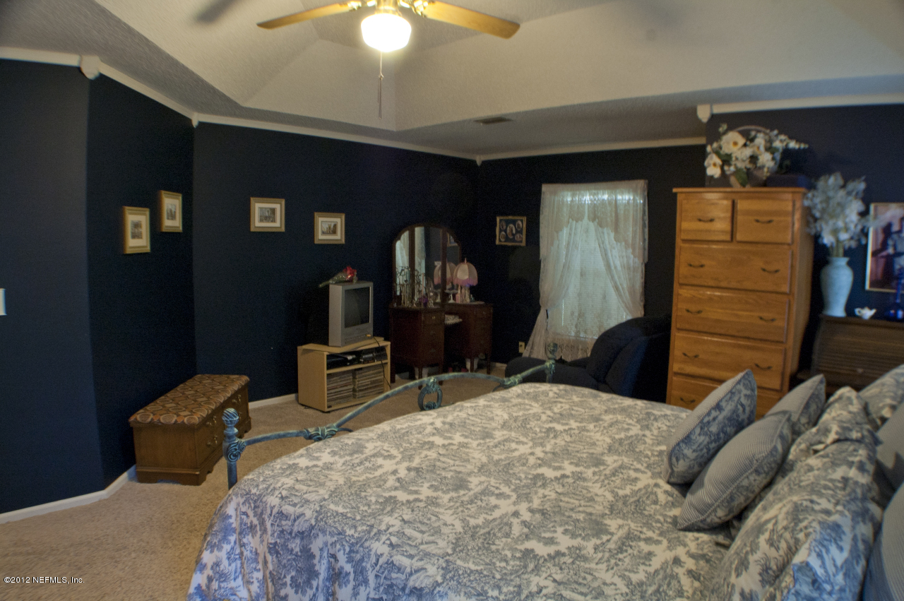 690 Roberts Road St. Johns, FL 32259 - Photo 19 of 32 a bedroom with a bed and a chandelier