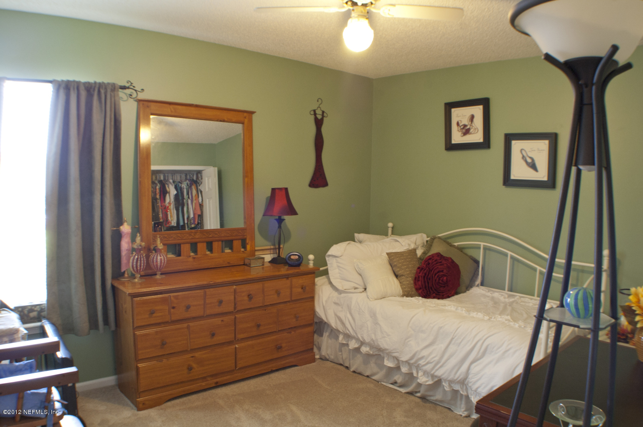 690 Roberts Road St. Johns, FL 32259 - Photo 26 of 32 a bedroom with a bed and a mirror on dresser