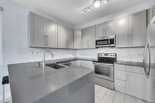 a kitchen with kitchen island a sink stainless steel appliances and cabinets
