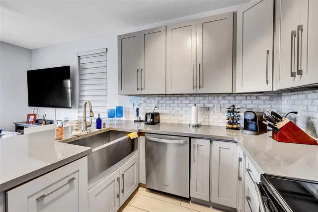 a kitchen with cabinets appliances a sink and a counter top space