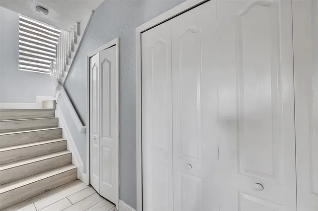 a view of staircase with white walls and white door