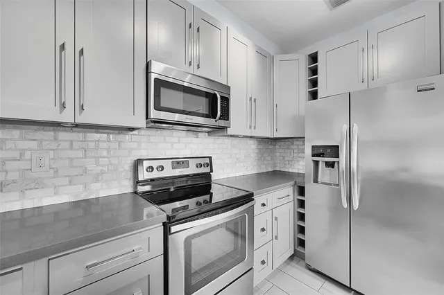 a kitchen with white cabinets stainless steel appliances and a counter space