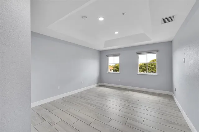 an empty room with windows and mirror