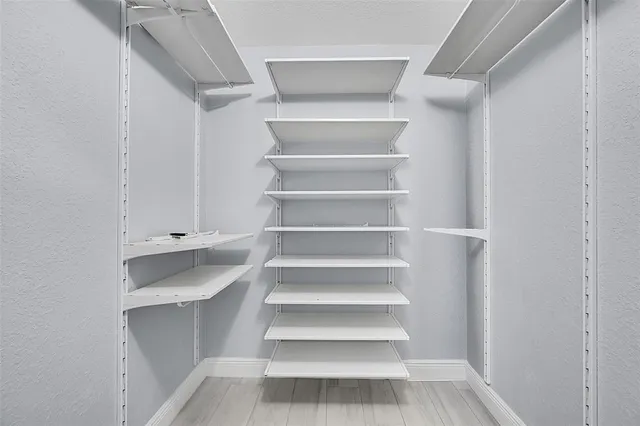 a view of walk in closet with empty racks