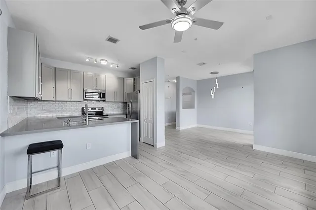 a large kitchen with cabinets and wooden floor