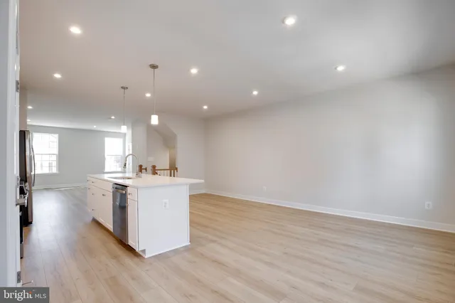 a kitchen with a stove and wooden floor