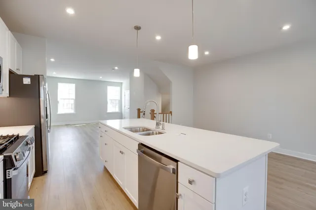 a view of a kitchen island a sink and dishwasher with wooden floor