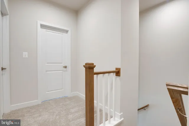 a view of a hallway with a white door and a glass door