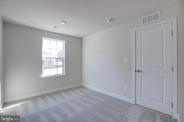 an empty room with windows and closet