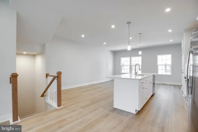 a large kitchen with a wooden floor and a sink