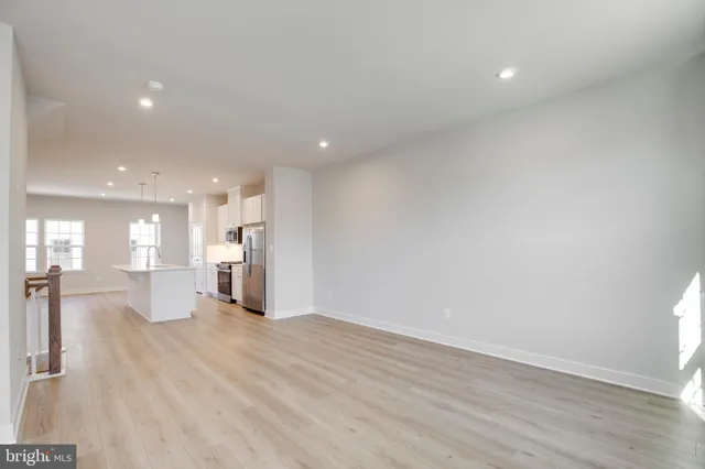 a view of a kitchen with a sink wooden floor and a living room