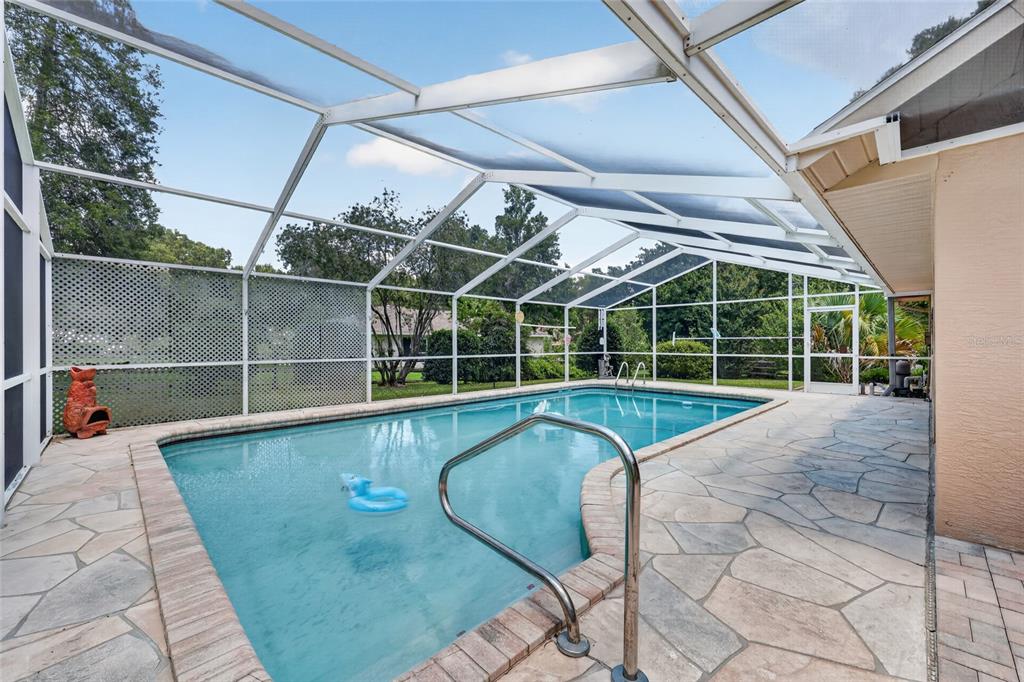 19025 Southwest 98th Loop Dunnellon, FL 34432 - Photo 50 of 80 a view of a swimming pool with a glass door and chair