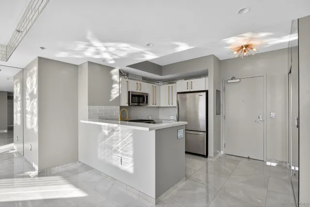 a kitchen with kitchen island stainless steel appliances a refrigerator stove top oven and sink